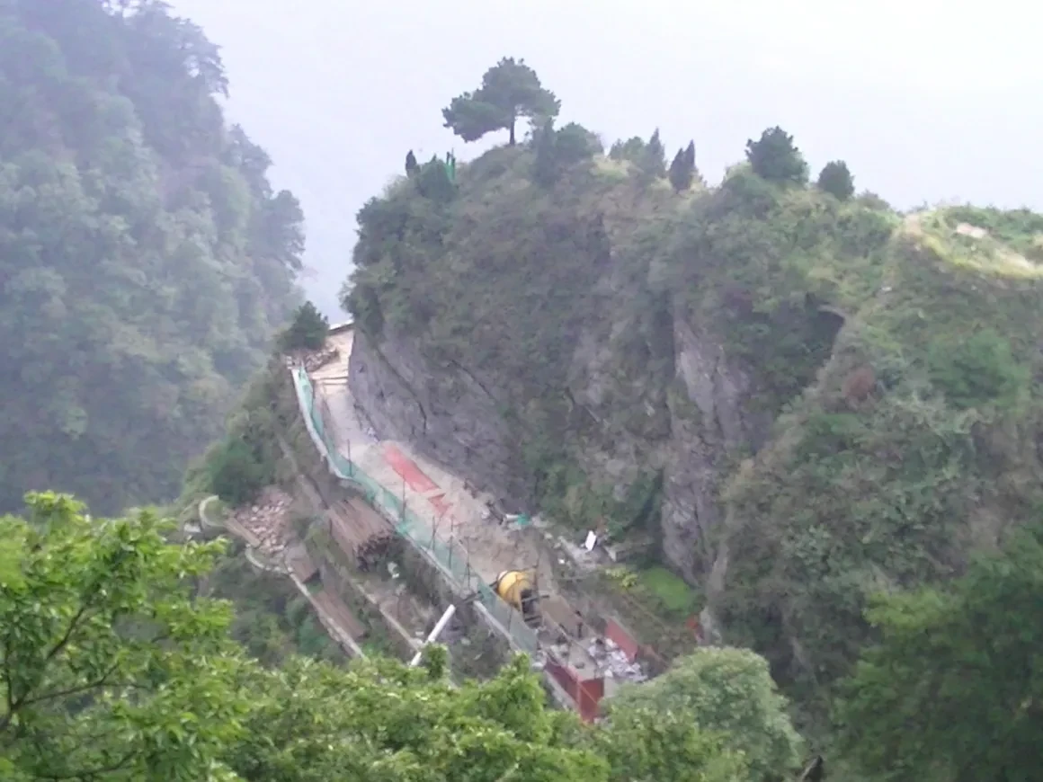 Misty mountain cliffside path and construction at Wudang