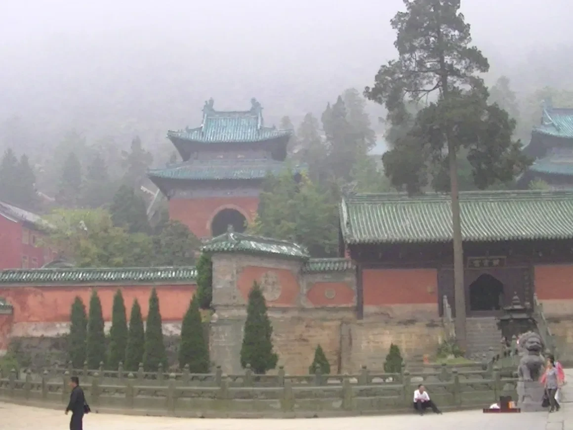 Wudang Mountain temple complex with red walls and blue-tiled roofs in the mist