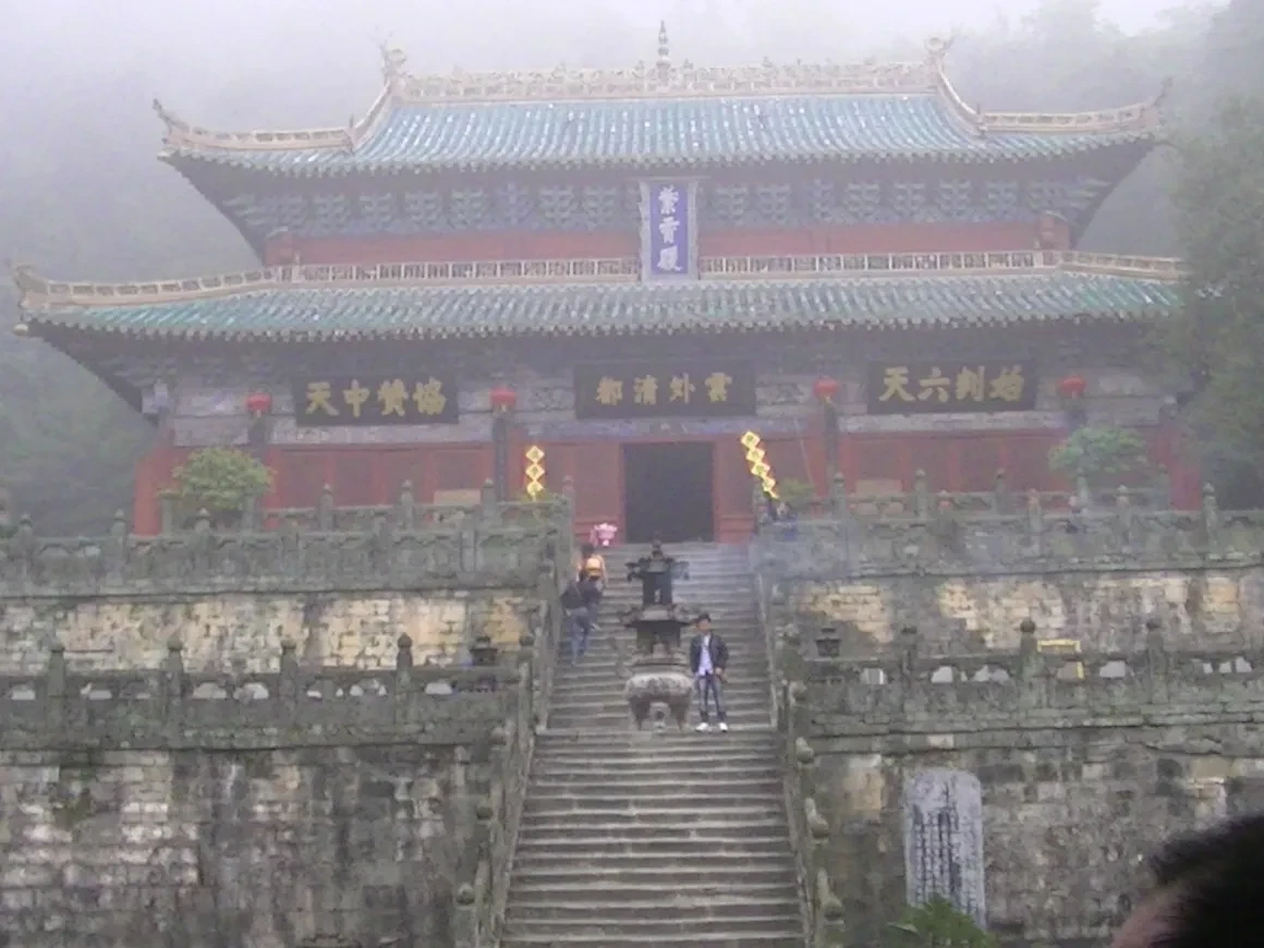 Wudang Mountain temple hall with stone steps rising through the mist