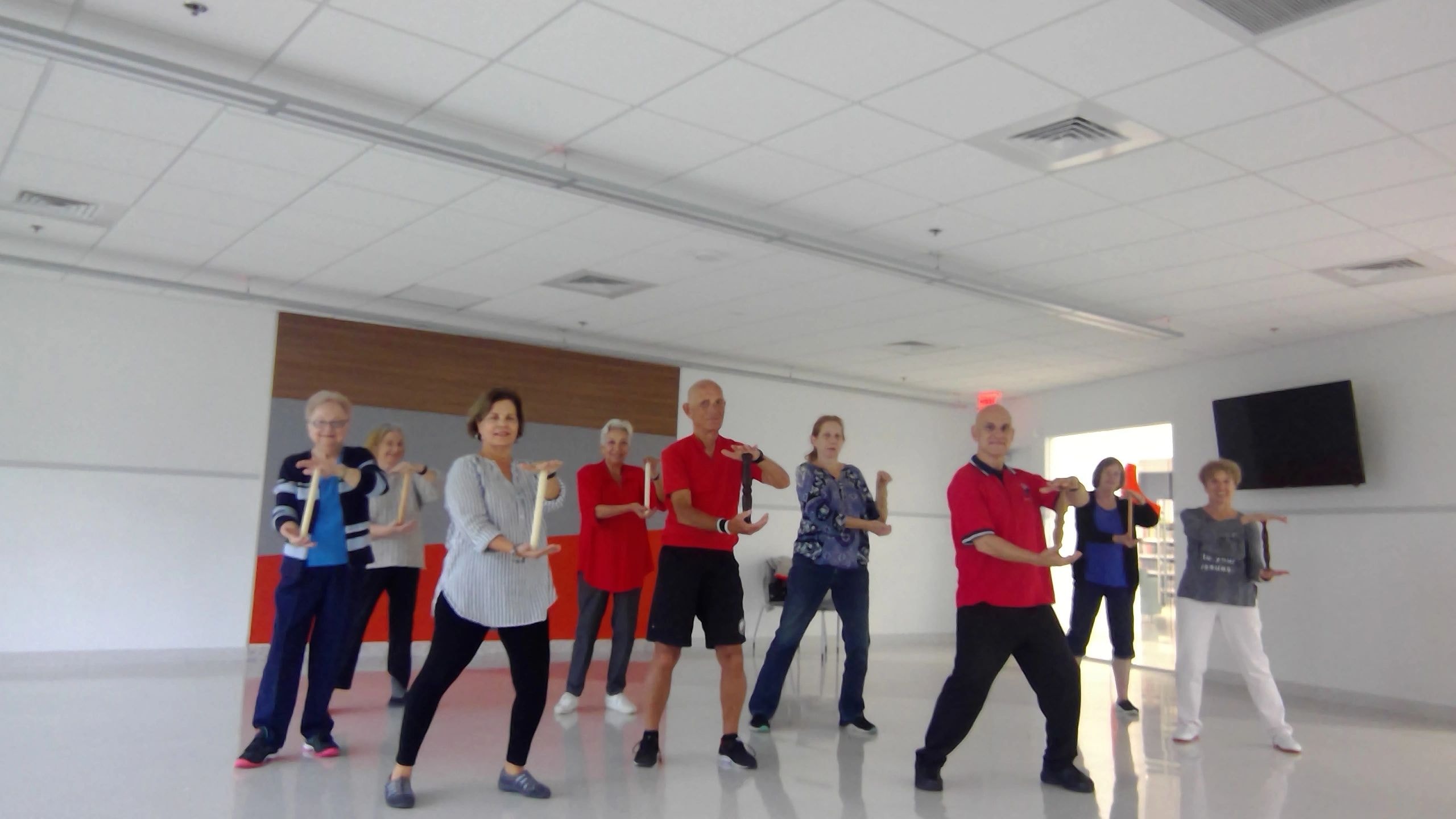 Tai Chi class with adults practicing flowing movements